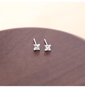 Macro shot of silver-colored square cubic zirconia stud earrings with a four-prong setting