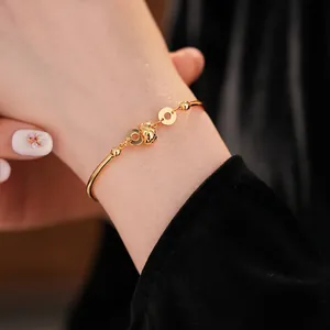 Elegant 18K gold plated bamboo link bracelet with zircon and woven orb on model