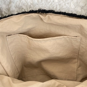 Detailed view of the striped dog bag interior featuring a patch pocket and beige lining