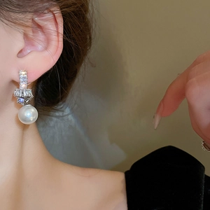 Elegant silver-tone knot earrings with sparkling cubic zirconia and large round pearls