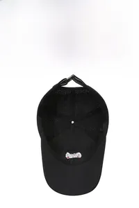 Detail of breathable laser-cut holes and red embroidered logo inside the black cap