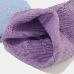 Detailed view of the purple and light blue knit hats showing thick weave texture