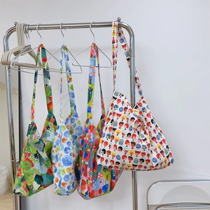 Set of four cotton tote bags with colorful floral and artistic patterns on hangers