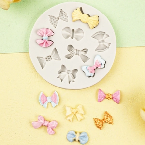Macro detail of multi-cavity silicone mold featuring various 3D bow shapes for DIY baking