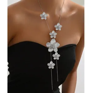 Detail of silver long tassel necklace with floral pendants on a black dress