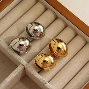 Polished teardrop earrings in gold and silver finish shown in a jewelry organizer box