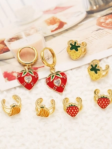 Detailed view of gold strawberry and banana fruit earrings with enamel and zircon inlay