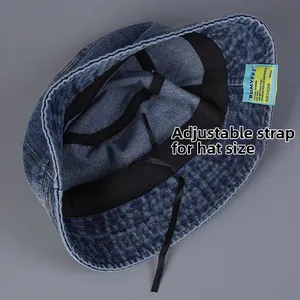 Detail of adjustable inner strap and woven label on dark blue denim bucket hat