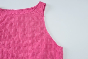 Détail du haut en tricot rose à carreaux montrant la texture seersucker et le tissu