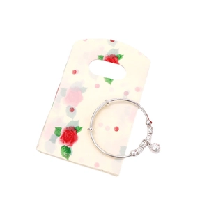 Silver adjustable baby bracelet with decorative beads and engraved bells on rose floral card