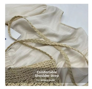 Detail of hand-woven straw shoulder bag with geometric hollow patterns and braided strap