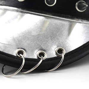 Macro detail of punk beret showing black leather, metallic fabric, and silver metal rings