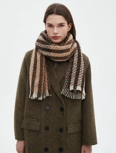 Close-up of brown and black striped knit scarf featuring decorative fringe tassels