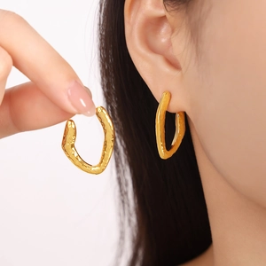 Textured 18K gold plated titanium steel geometric earrings shown on a model