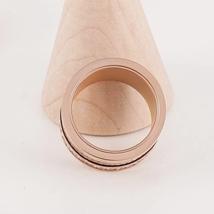Detailed view of rose gold ring with pavé diamonds and Roman numeral spiral design