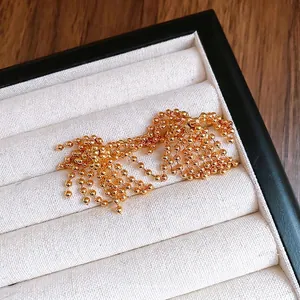 Elegant gold plated fireworks tassel earrings with ball chains in jewelry box