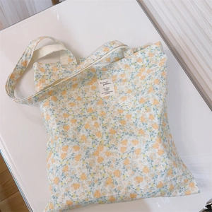 Close-up of floral canvas tote bag featuring yellow flower patterns and a fabric label