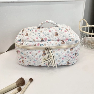 Close-up of quilted cotton makeup bag featuring cute bear pattern and decorative ribbon
