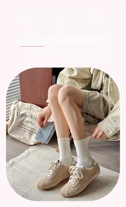 Detail shot of cream white mid-calf socks with grey star patterns and elastic cuffs