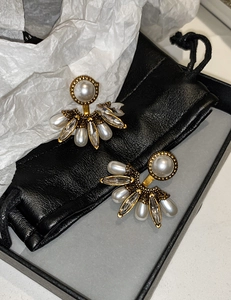 Gros plan détaillé de boucles d'oreilles perles vintage dans un écrin noir