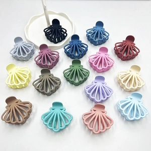 Detailed view of matte shell-shaped hair claws in various vibrant colors on white background
