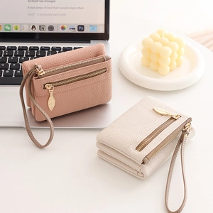 Detail of dual zipper closure and leaf pulls on pebble leather wallets with wristlets