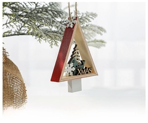 Macro view of a wooden Christmas tree pendant with reindeer and XMAS motif on a branch