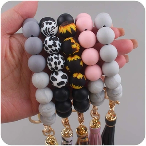 Silicone bead keychain bracelets with tassels in cow print, floral, and solid colors