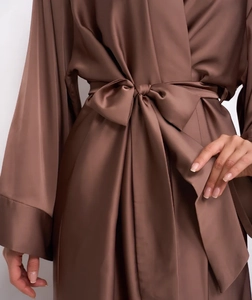 Détail d'un peignoir en satin marron foncé montrant le nœud et la texture soyeuse