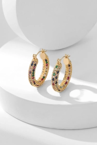 Macro shot of colorful pave-set zircon stones on gold-plated round hoop earrings