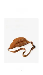 Detail of brown corduroy texture and golden metal zipper on this stylish chest bag