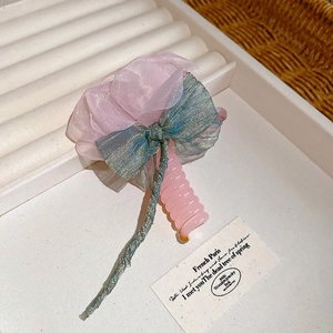 Close-up of sweet pink mesh flower hair accessory with sparkly blue ribbon and cord stem.