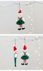 Detailed close-up of Christmas elf doll ornaments with plush texture on a white branch