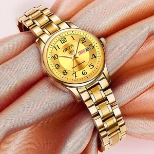 Détail du cadran de montre à quartz dorée avec double calendrier sur fond de soie