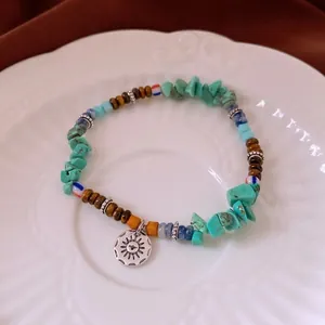 Bracelet perlé bohème avec pierres de turquoise irrégulières, oeil de tigre et charme soleil