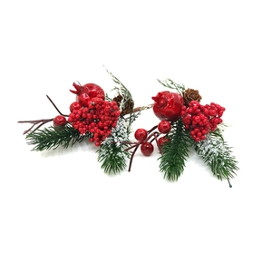 Dettaglio di rami decorativi natalizi con bacche rosse, aghi di pino e pigne naturali