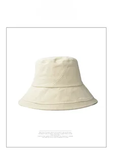 Detailed view of cream cotton bucket hat featuring unique cross-stitched decorative seams