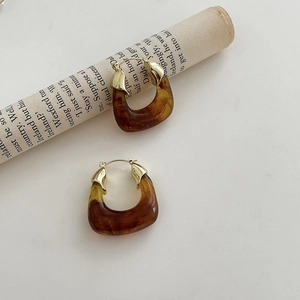 Detailed macro view of amber resin hoop earrings with elegant gold metal clasps