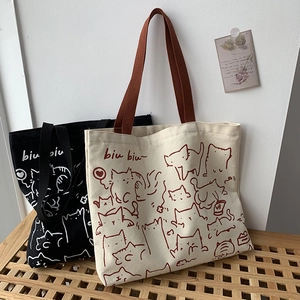 Close-up of artistic cat illustration on minimalist canvas tote bags in white and black
