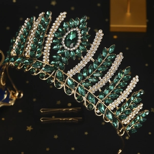 Detailed shot of golden bridal crown featuring emerald gemstones and sparkling crystals