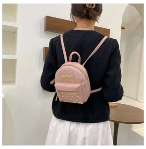 Pink mini backpack detail featuring gold rivet studs and metallic zipper hardware