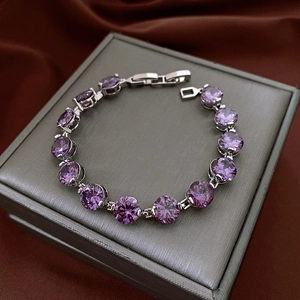 Detail of round purple zircon bracelet with silver claw setting on a gift box