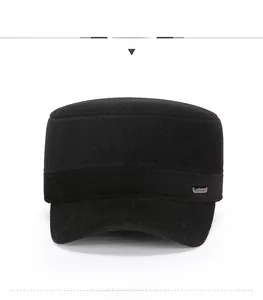 Front view of a thick black wool military flat top cap with a metal side plaque