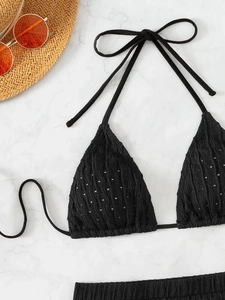 Detail of black halter bikini top with textured fabric and small ventilation holes