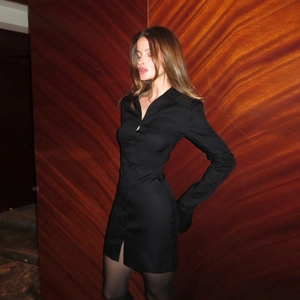 Détail d'une robe chemise noire moulante montrant le boutonnage et la texture du col