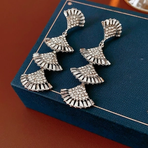Detailed view of layered fan-shaped silver earrings with sparkling rhinestones in a gift box