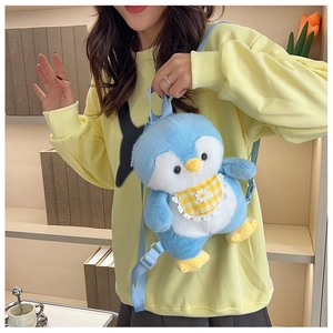 Soft light blue plush penguin backpack with floral lace bib worn on a model's back