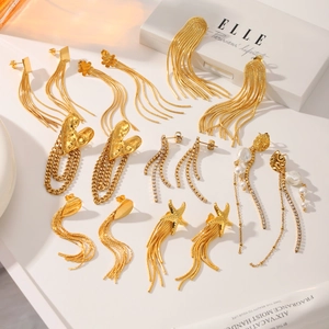 Detailed close-up of gold tassel earrings set with heart, starfish, and pearl accents