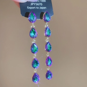 Detail of colorful gradient waterdrop earrings with sparkling starburst effect
