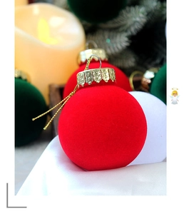 Detailed view of red flocked velvet Christmas ornament with embossed gold cap and hanger